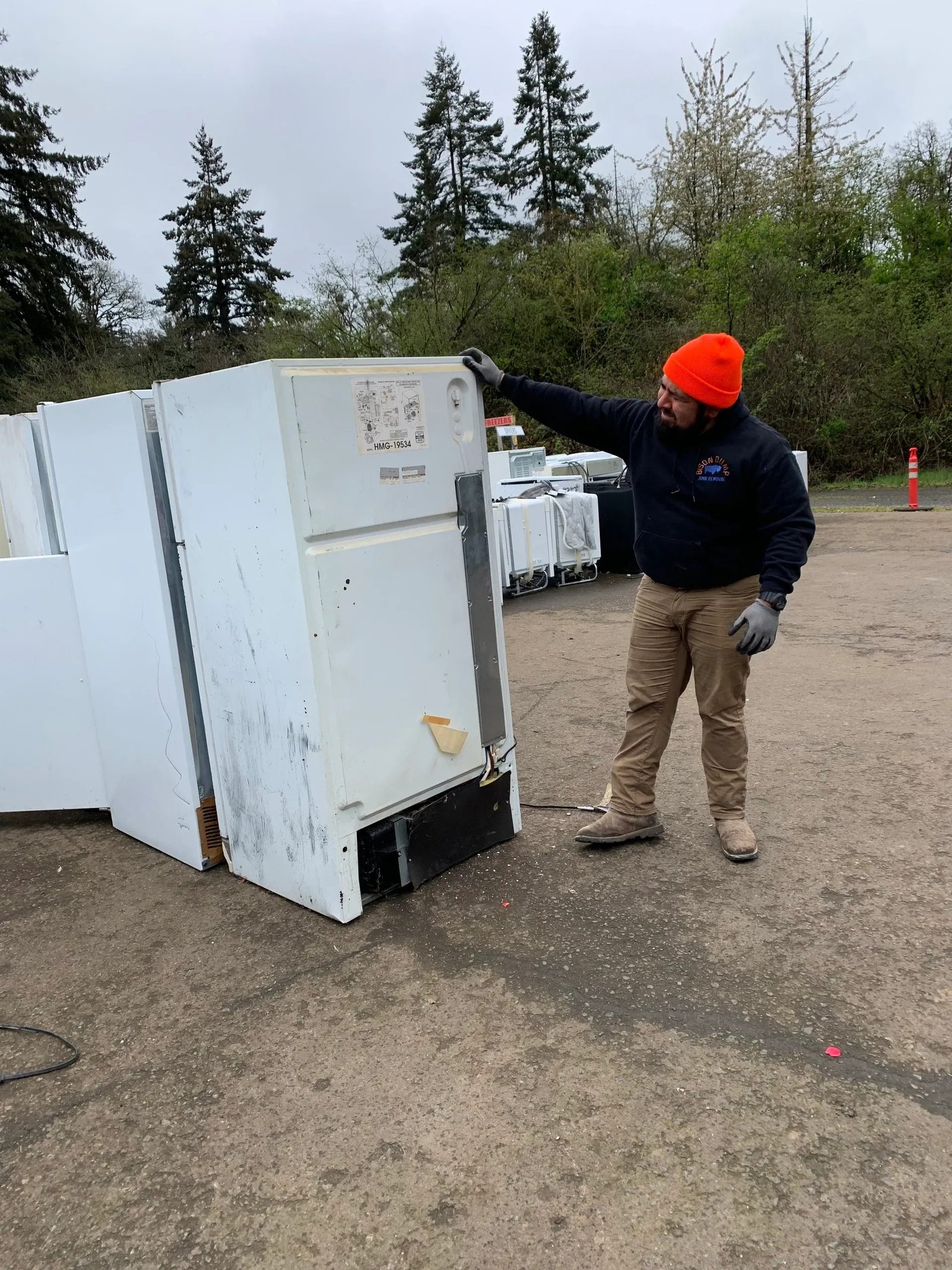 Bison Dump worker removing a large appliance during a Salem cleanout
